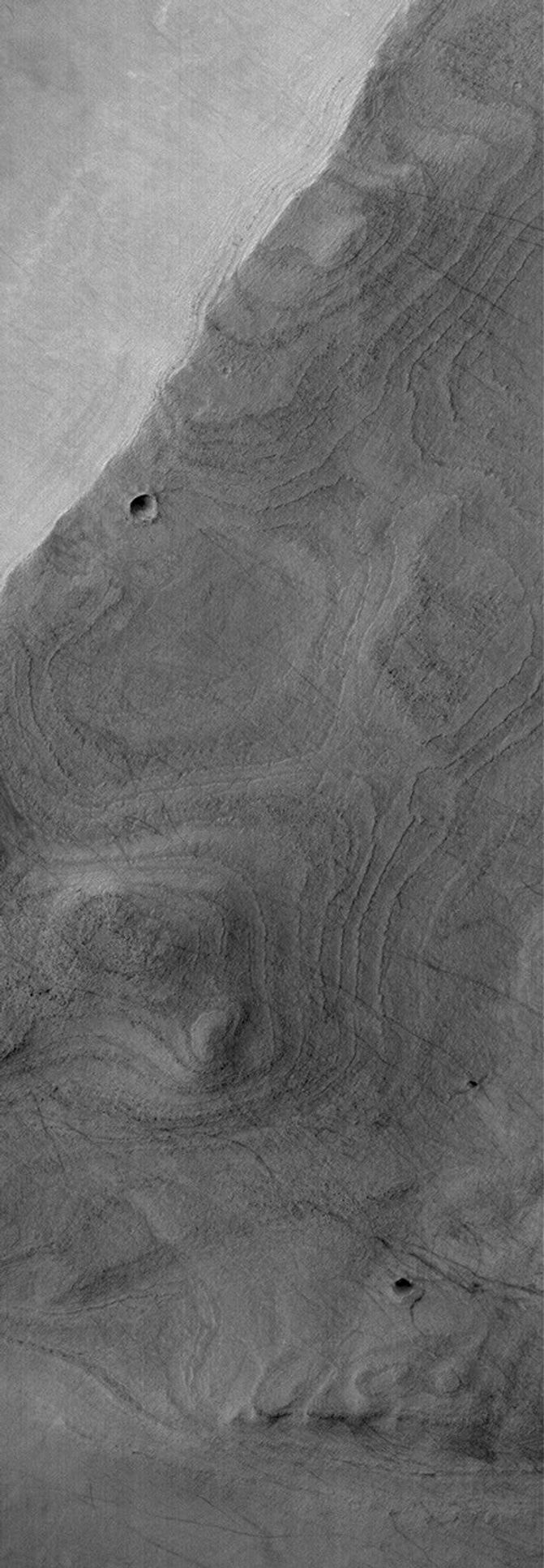 NASA's Mars Global Surveyor shows a banded surface in Argyre Planitia, the second largest impact basin in the martian southern hemisphere. The bands are the erosional expression of layered, perhaps sedimentary, rock.