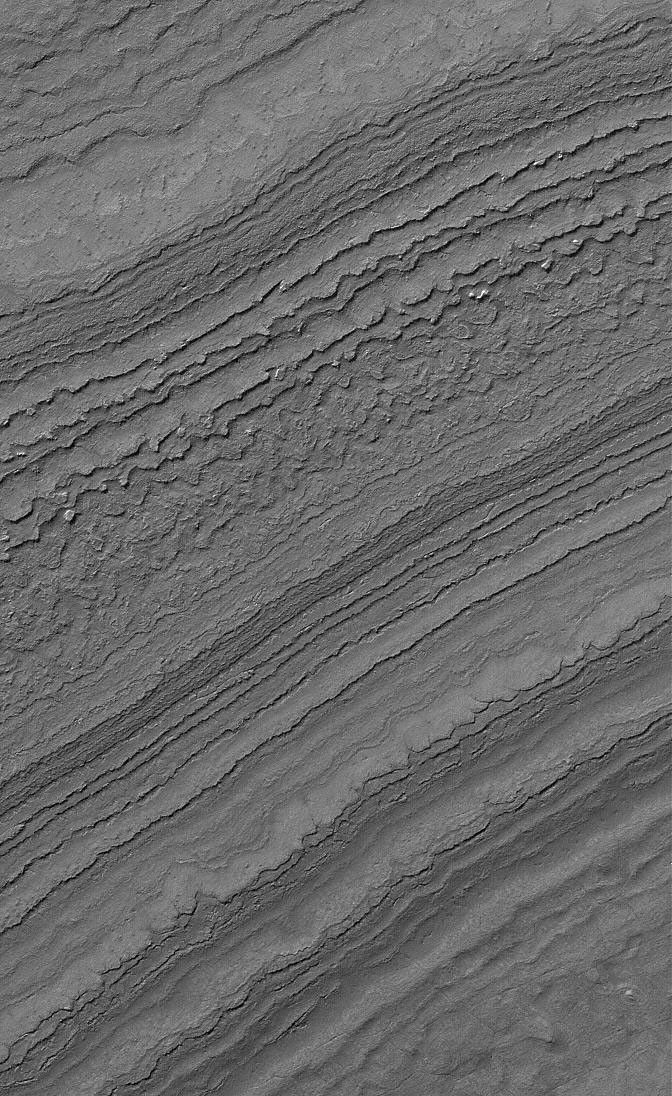 NASA's Mars Global Surveyor shows layers exposed by erosion on a slope in the martian south polar region. Both polar caps on Mars are underlain by a complex stratigraphy of layered material.