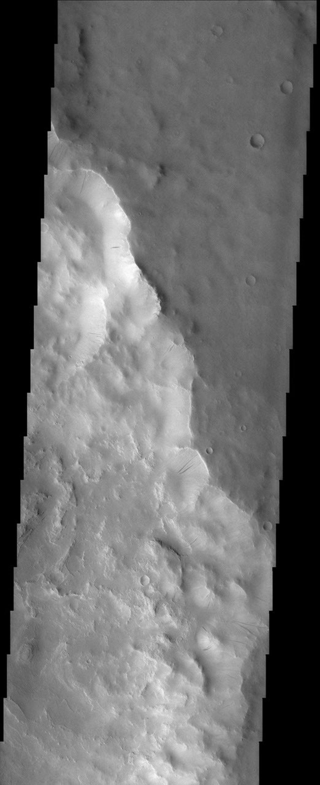 This image, captured by NASA's 2001 Mars Odyssey spacecraft, shows that this portion of the rim of Henry Crater has numerous dark streaks located on the slopes of the inner crater wall.