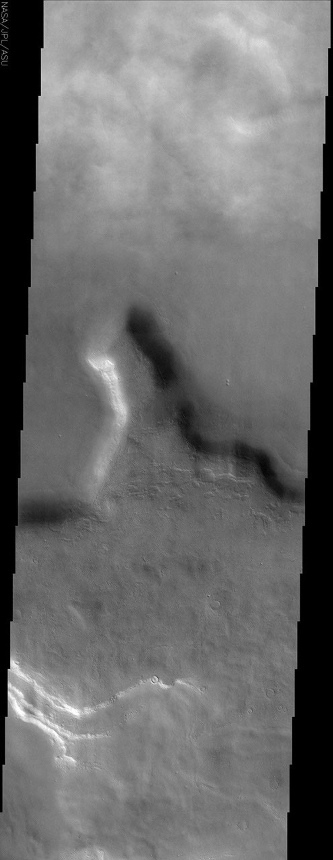 This image by NASA's Mars Odyssey spacecraft shows a region of northern Tempe Terra. Patchy water-ice clouds cover portions of the low-lying canyon at the top (north) of this image.