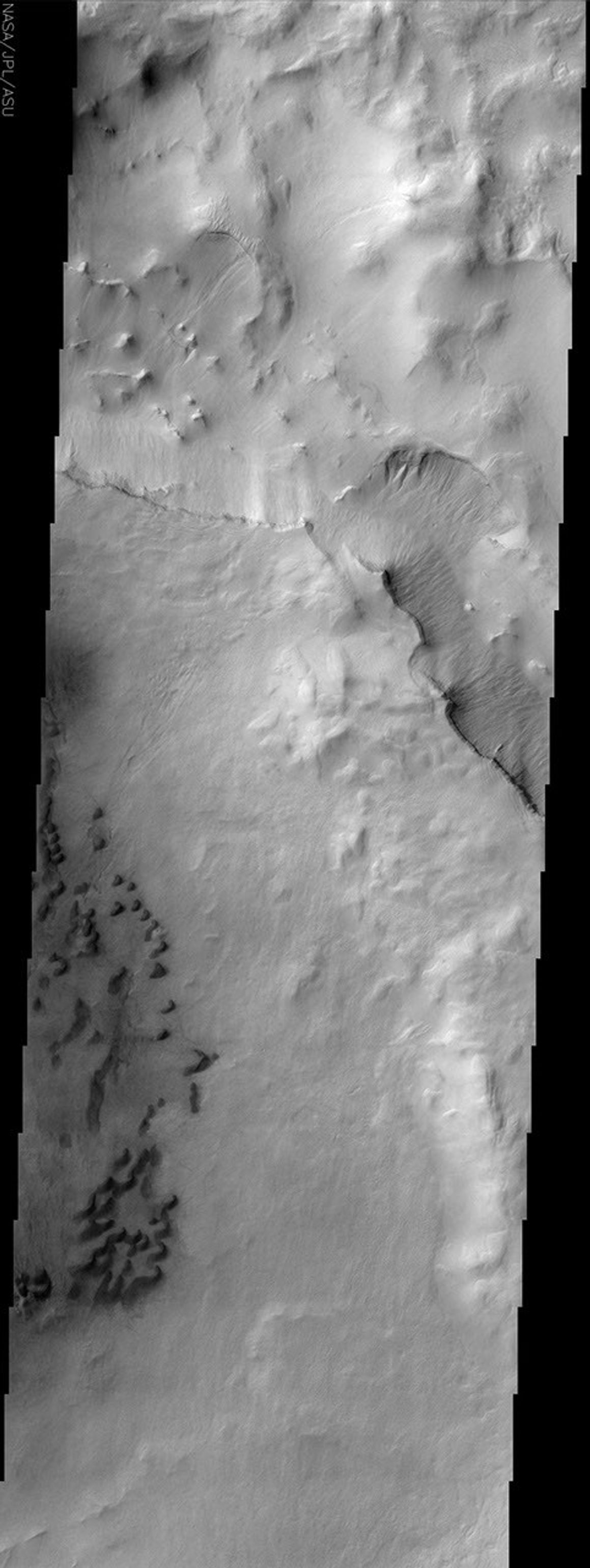 This image taken by NASA's Mars Odyssey spacecraft shows a portion of Maunder Crater with a number of interesting features including a series of barchan dunes that are traveling from right to left and gullies.