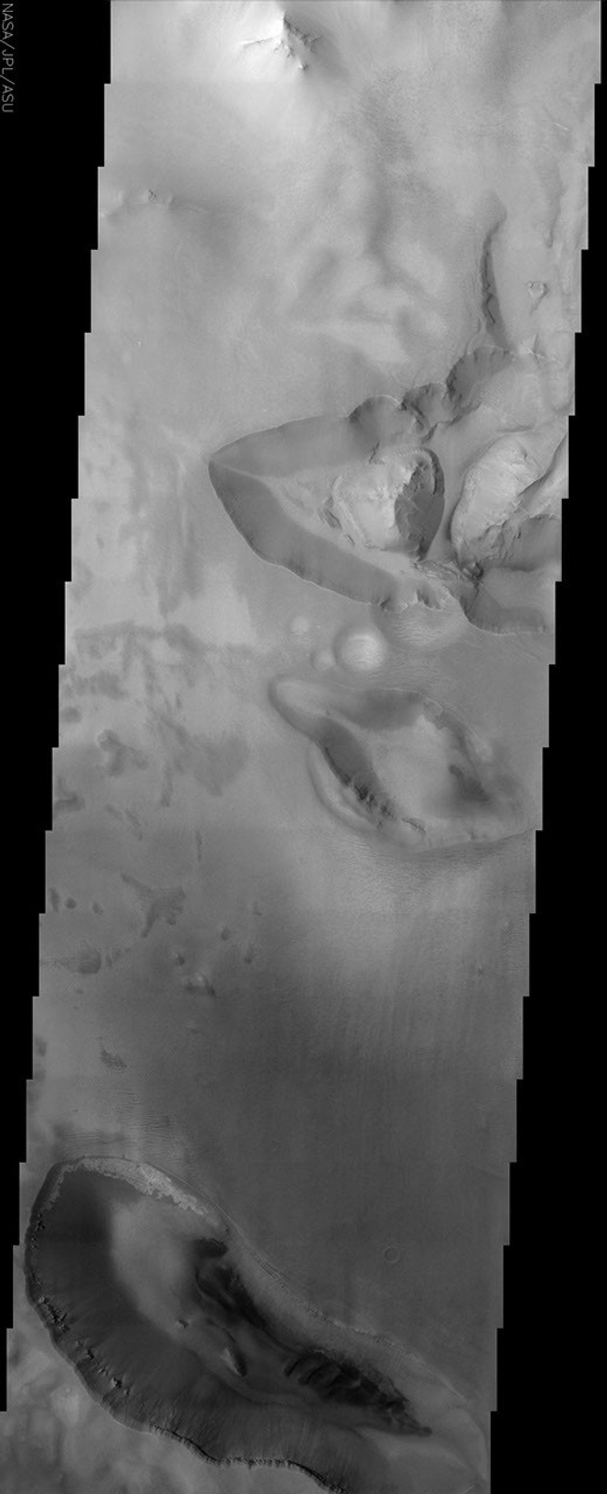 This NASA Mars Odyssey image shows the transition zone between maze-like troughs of Noctis Labyrinthus and the main Valles Marineris canyon system. This huge system of troughs near the equator of Mars was most likely created by tectonic forces.