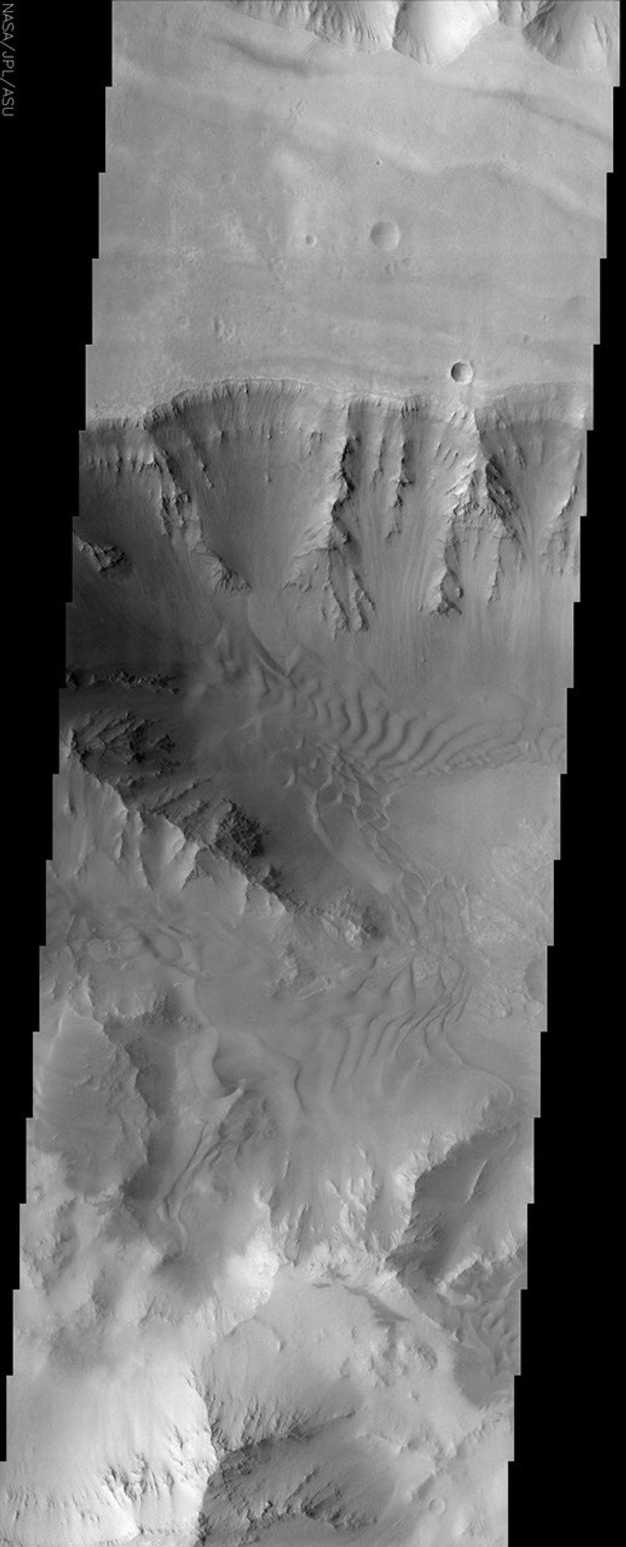 This image from NASA's Mars Odyssey spacecraft, which displays clearly the contrast between bedrock, sand, and dust surfaces, covers a portion of Coprates Chasma, part of the Valles Marineris system of canyons that stretch for thousands of kilometers.