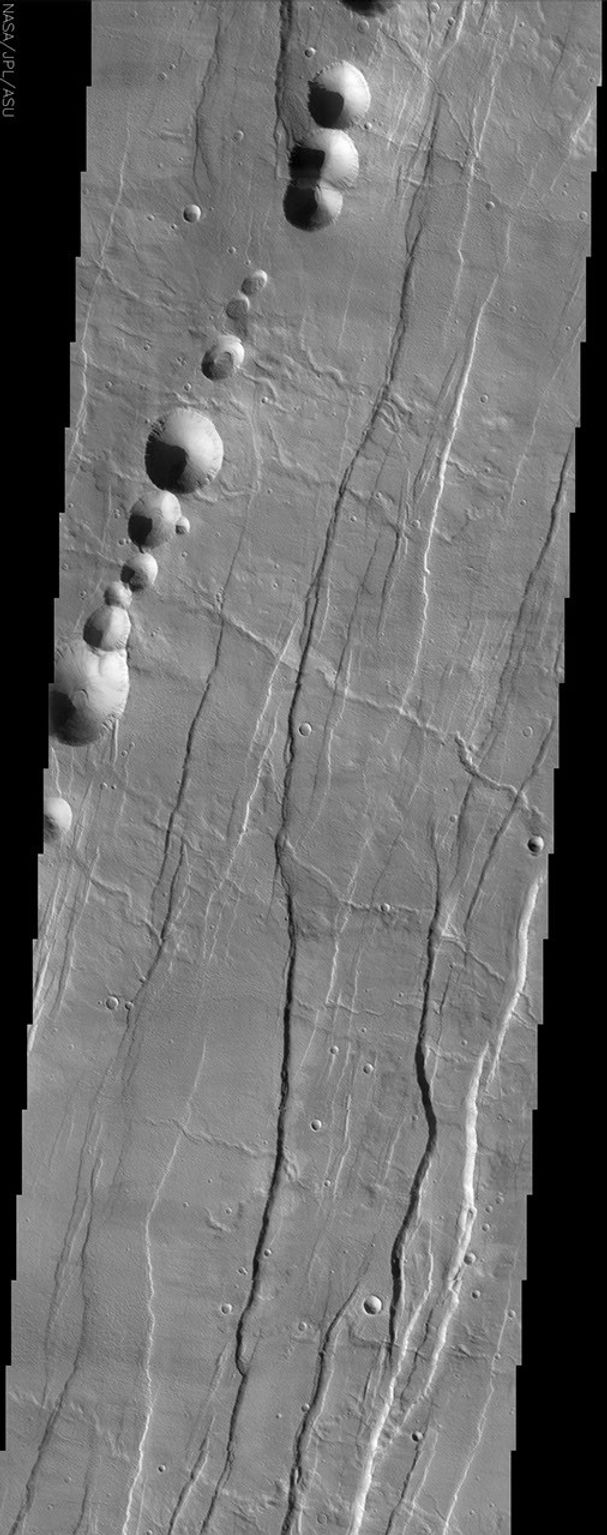 Tantalus Fossae, seen in this image from NASA's Mars Odyssey spacecraft, is a set of long valleys on the eastern side of Alba Patera. These valleys are referred to as grabens and are formed by extension of the crust and faulting.
