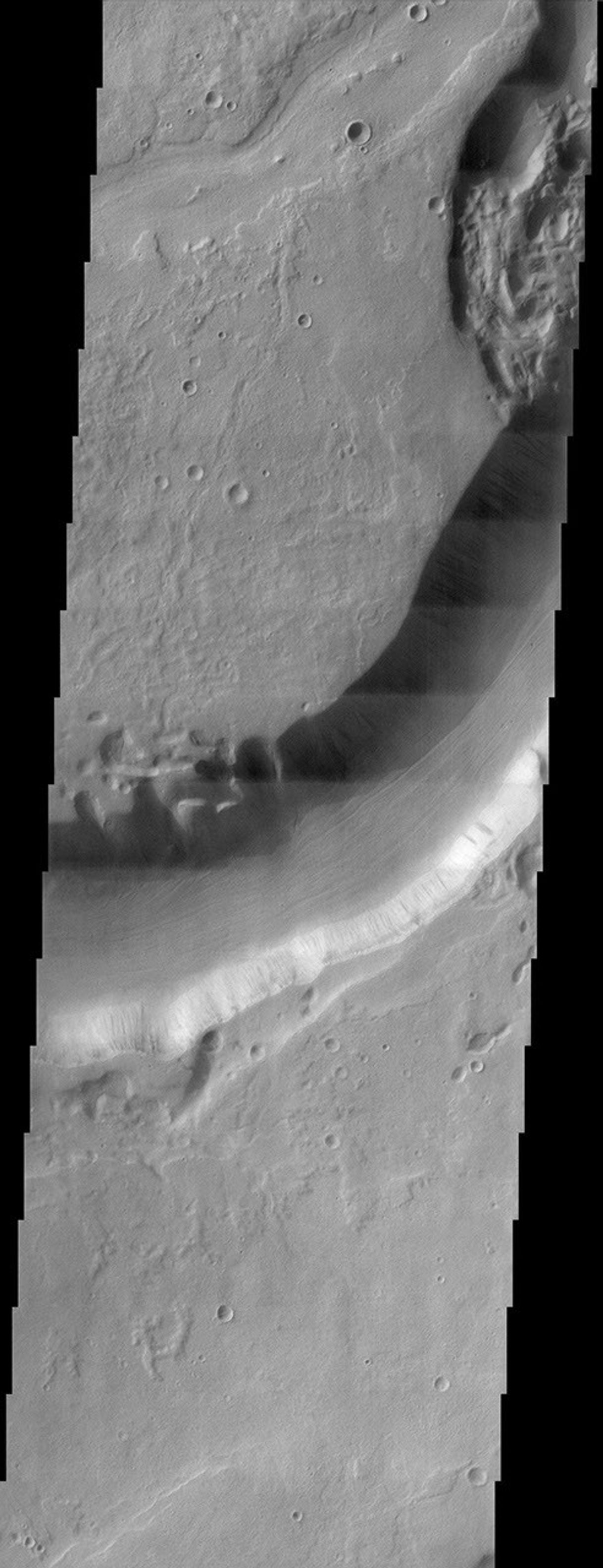 This NASA Mars Odyssey image shows Dao Vallis, a large outflow channel that starts on the southeast flank of a large volcano called Hadriaca Patera and runs for 1,000 kilometers (about 620 miles) southwest into the Hellas impact basin.