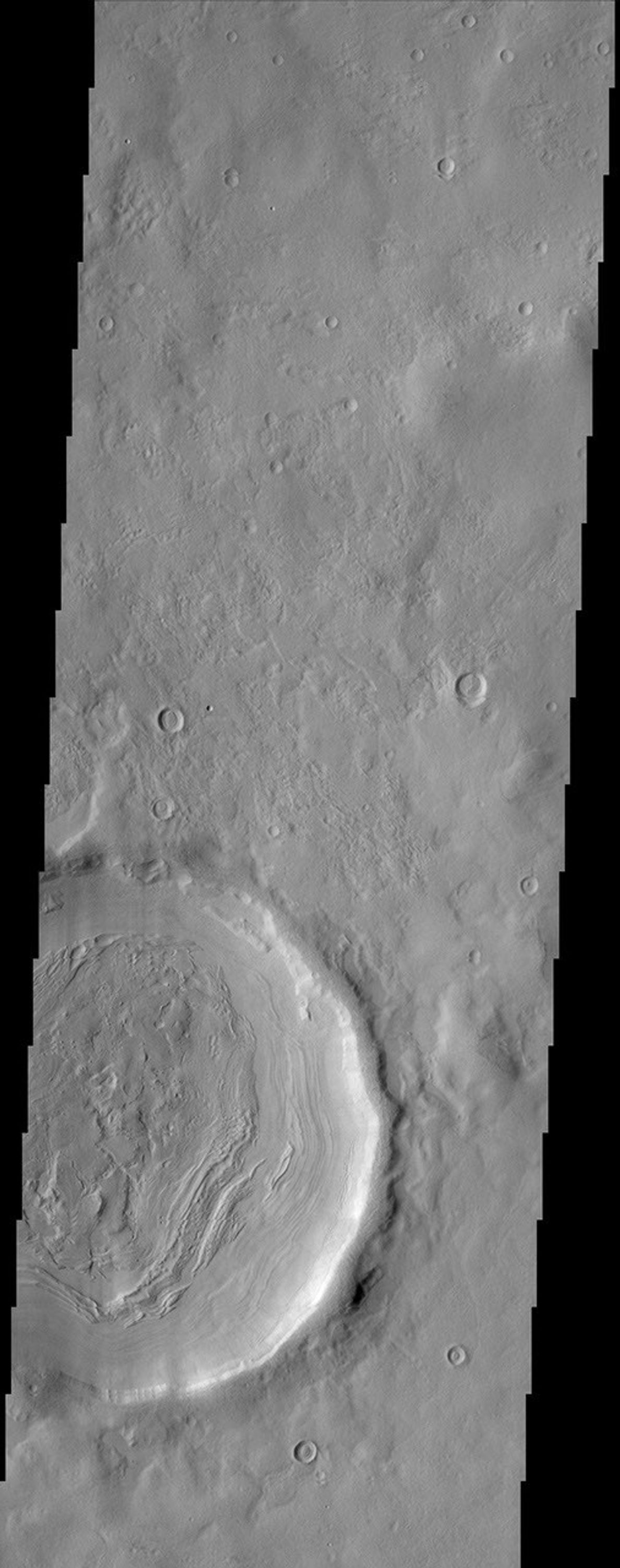 The layering of material observed at the bottom of this impact crater imaged by NASA's Mars Odyssey spacecraft suggests multiple depositional and erosional episodes in a changing environment.