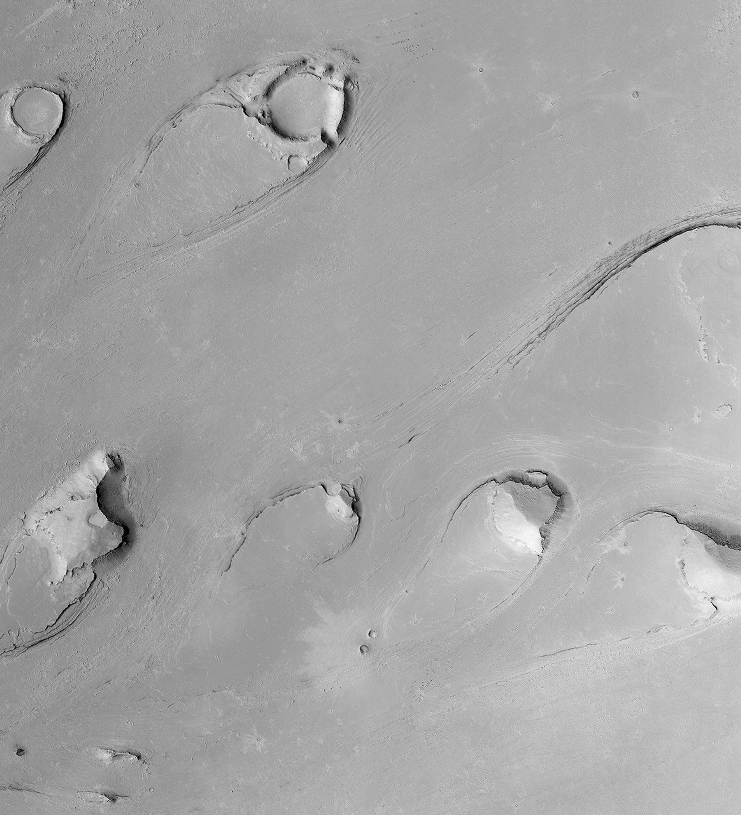 NASA's Mars Global Surveyor shows tear drop-shaped landforms in Athabasca Vallis in the Cerberus region of Mars, south of the Elysium volcanoes.