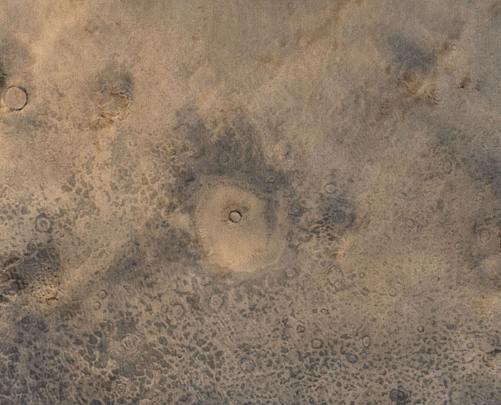 NASA's Mars Global Surveyor shows a few craters at the surface of Mars' northern plains, and several circular features that represent craters that are mostly buried beneath the plains.