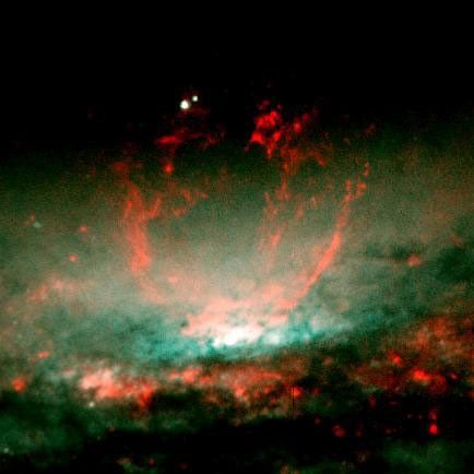 A lumpy bubble of hot gas rises from a cauldron of glowing matter in a distant galaxy, as seen by NASA's Hubble Space Telescope.