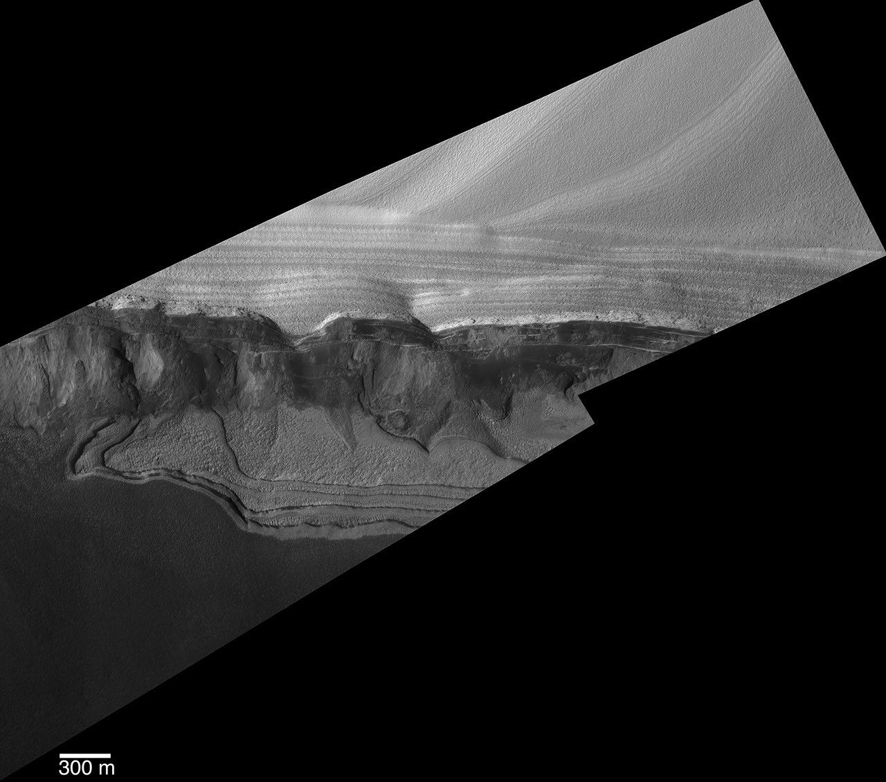 NASA's Mars Global Surveyor shows sharp detail of a scarp at the head of Chasma Boreale, a large trough cut by erosion into the martian north polar cap and the layered material beneath the ice cap.
