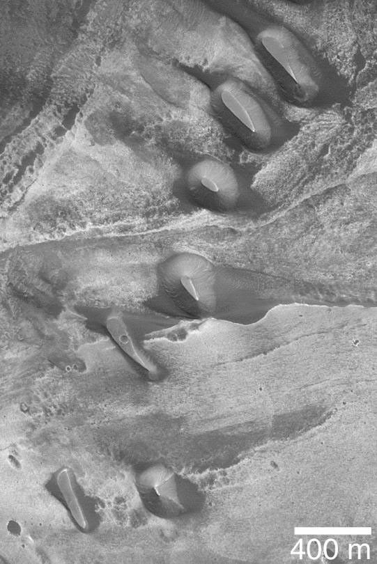 NASA's Mars Global Surveyor shows dark-toned buttes of possible sedimentary rock in southern Melas Chasma on Mars.