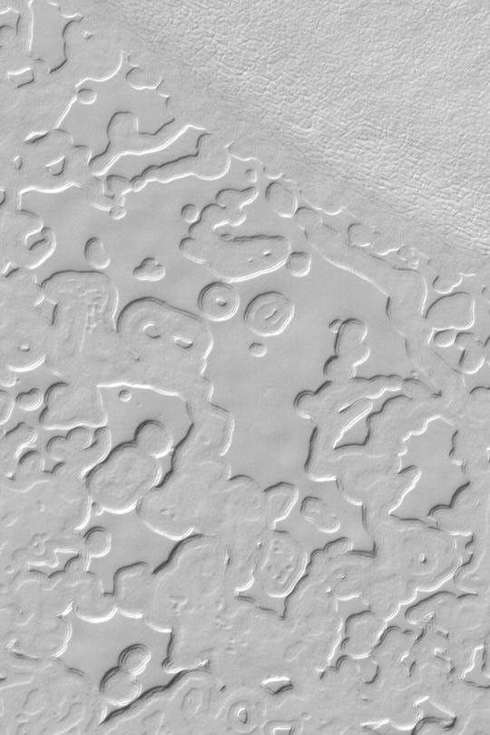 NASA's Mars Global Surveyor shows the 'swiss cheese' pattern of frozen carbon dioxide on the south polar residual cap.