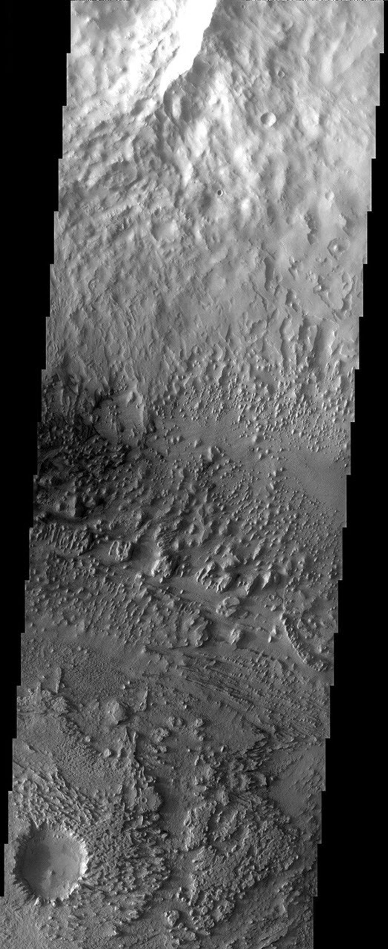 Streamlined buttes and mesas are left as remnants of an erosive wind that has carried away sediments and even the rim of a small crater in this image from NASA's Mars Odyssey spacecraft.