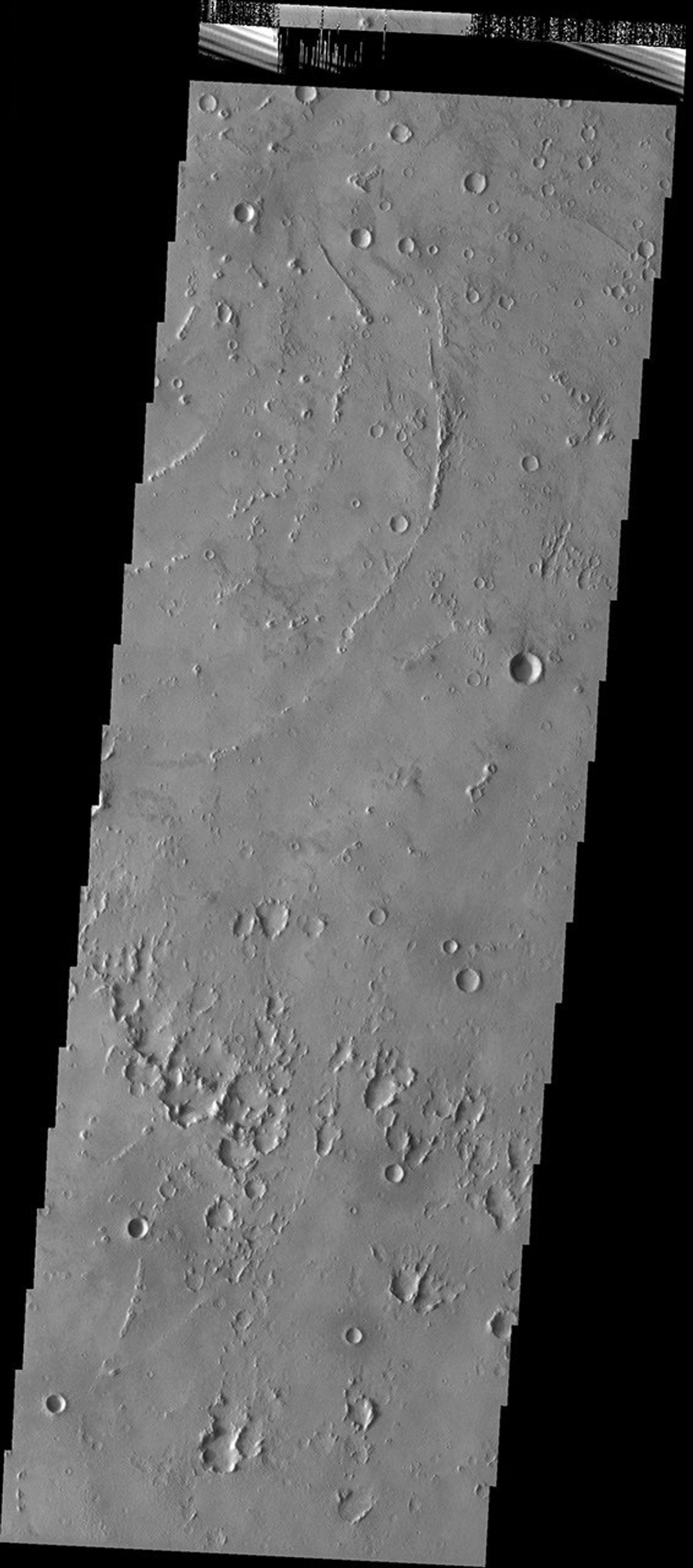 Just south of the 2 km high main mass of the Medusae Fossae Formation, in a region dissected by channels, lies an unnamed crater that may have been filled by mud, as seen by NASA's Mars Odyssey.