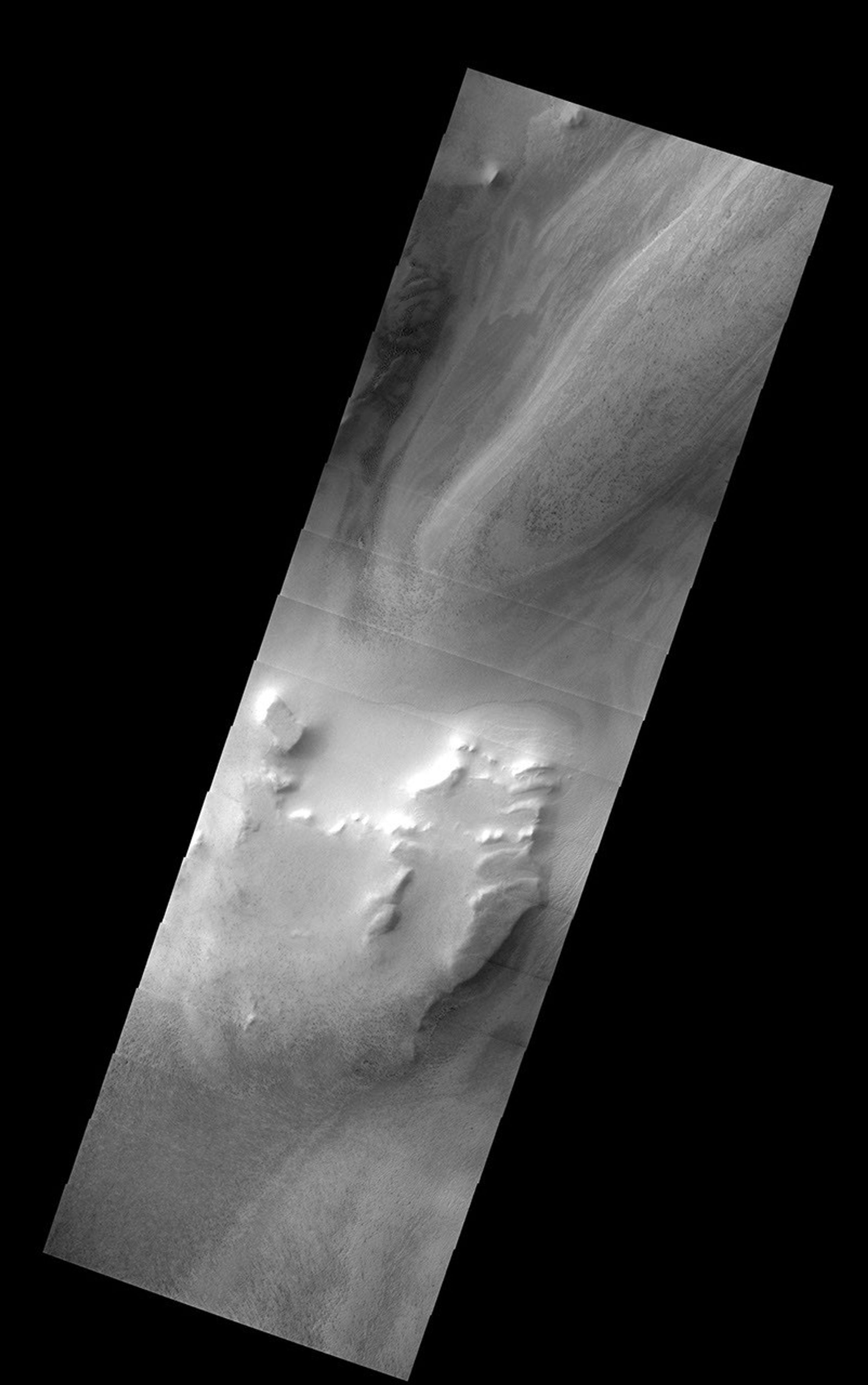 NASA's Mars Odyssey spacecraft captured this image in July 2003, showing fine-scale layered deposits in both N/S polar regions. At the south pole, alternating light and dark bands represent varying amounts of dust or sand mixed in with carbon dioxide ice.