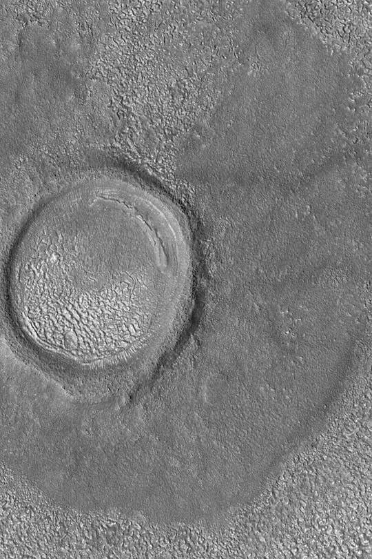 NASA's Mars Global Surveyor shows a strangely-textured floor on Mars. The original crater has been somewhat eroded and much of its interior has been filled with sediment since it formed.