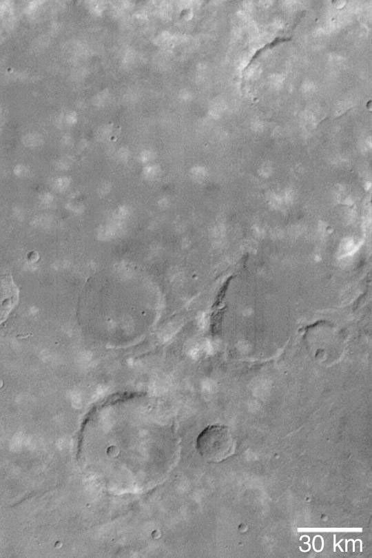NASA's Mars Global Surveyor shows small, puffy, water ice clouds over a cratered terrain near Icaria Planum on Mars.