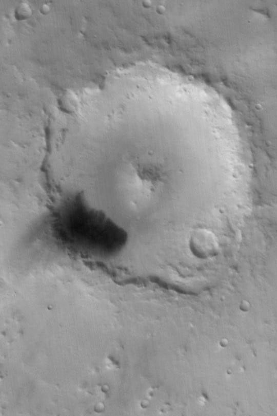 NASA's Mars Global Surveyor shows autumn view of Peridier Crater on Mars taken on August 6, 2003. Fine, dark-toned sediment has been blown out of the dune field and settled on the crater rim.