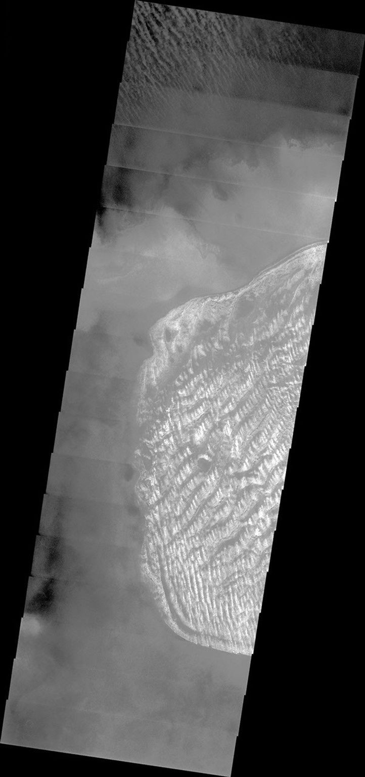 NASA's Mars Odyssey spacecraft captured this image in August 2003, showing a crater named after a Swedish astronomer, Charlier, hosts a dune field that is brightened by a layer of frost on Mars.
