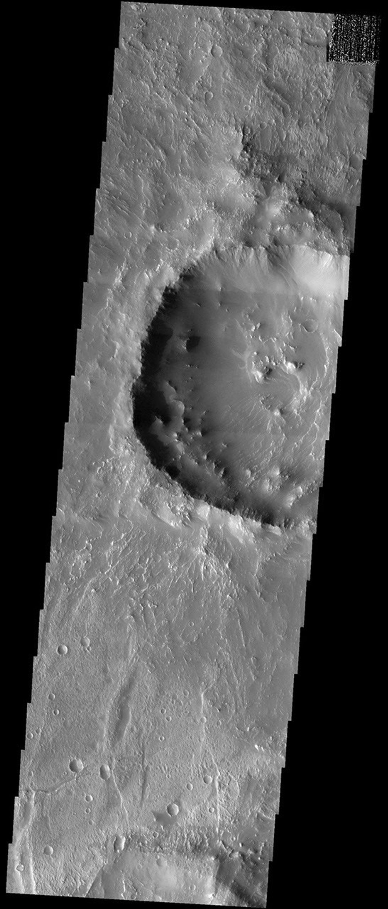 NASA's Mars Odyssey spacecraft captured this image in August 2003, showing Koga crater, named for a town in Tanzania. It is located in a region called Claritas Fossae on Mars. A mantle of fine material that is draped over much of the terrain.