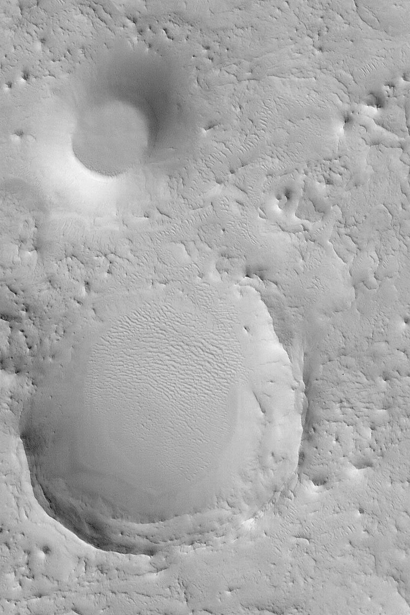 NASA's Mars Global Surveyor shows the remains of two former meteor impact craters in northeastern Arabia Terra on Mars.