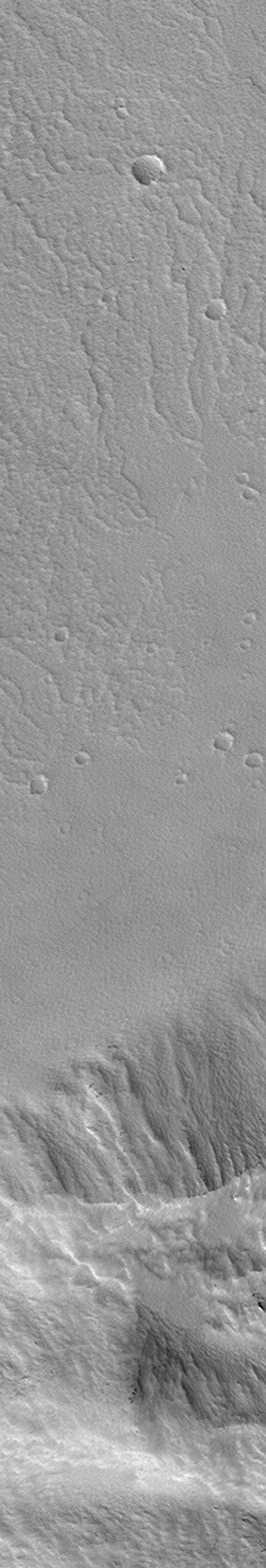 NASA's Mars Global Surveyor shows a portion of the lower wall and floor of the caldera at the top of a martian volcano named Pavonis Mons on Mars.