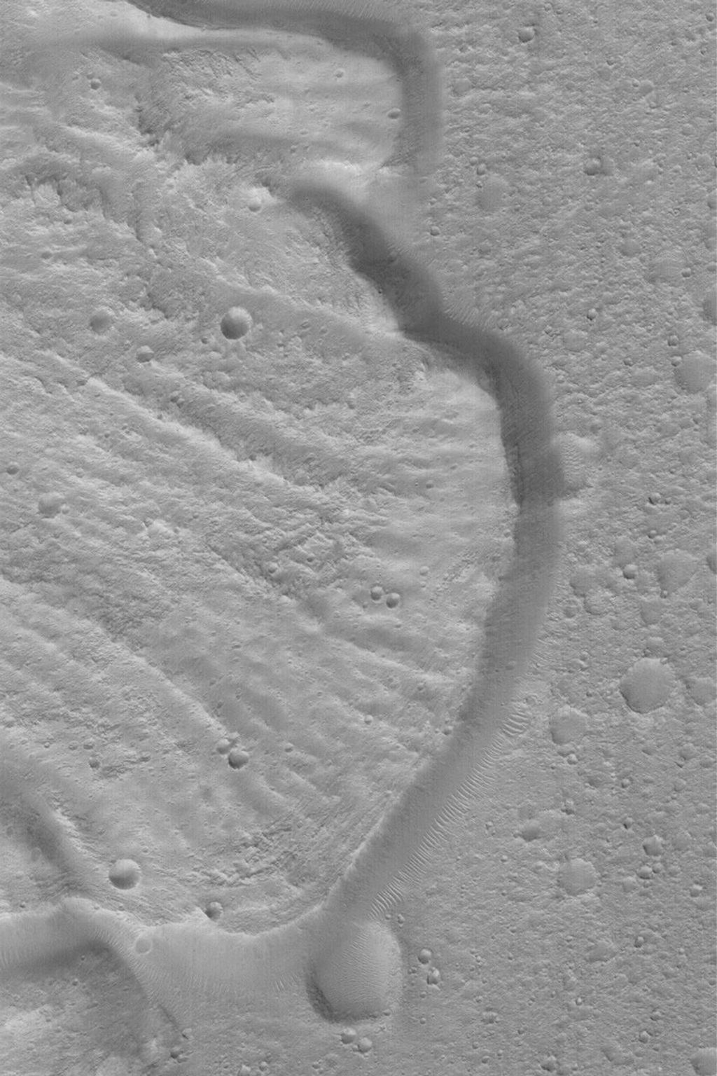 NASA's Mars Global Surveyor shows part of a deposit created by a landslide off the wall of a crater on Mars. These layers represent a long history of sedimentation that occurred in Gale Crater at some time in the distant martian past.