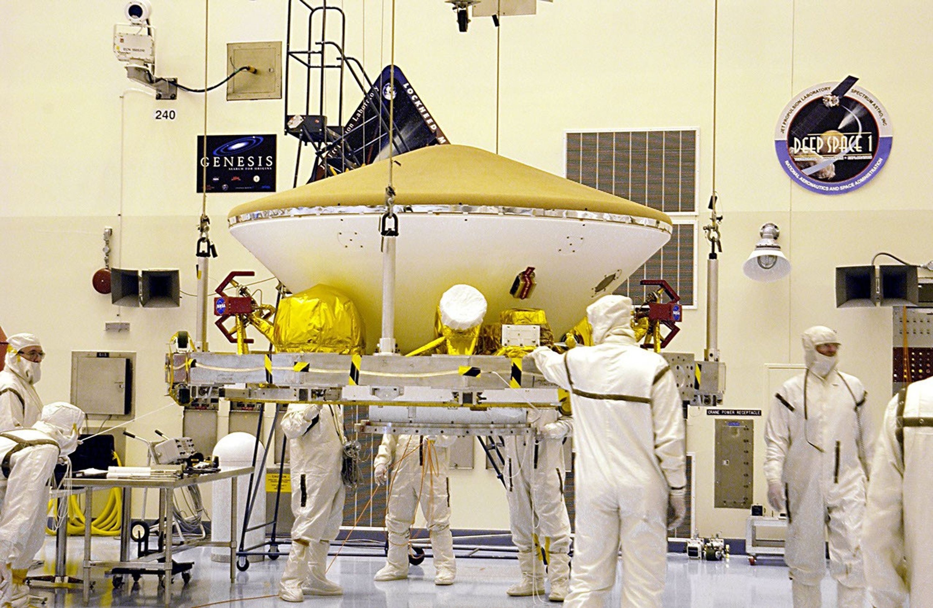Suspended by an overhead crane in the Payload Hazardous Servicing Facility, the Mars Exploration Rover (MER) aeroshell is guided by workers as it moves to a rotation stand.