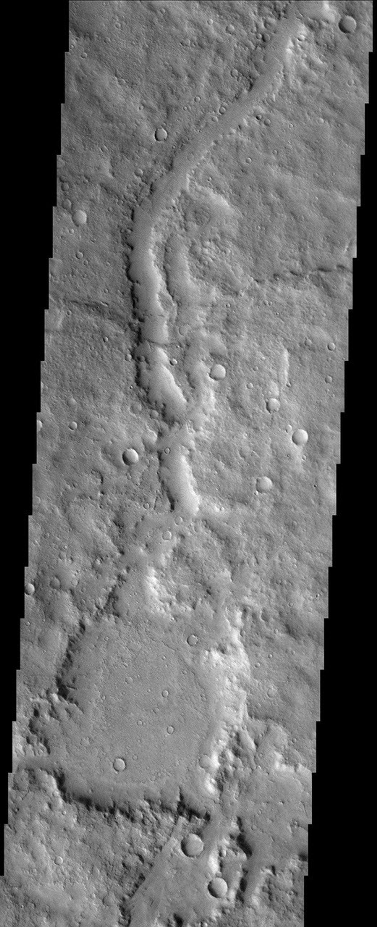 This region of the cratered highlands looks very ancient. A degraded channel snakes its way across the scene and enters what may be an older crater. This image was captured by NASA's Mars Odyssey spacecraft in November 2003.