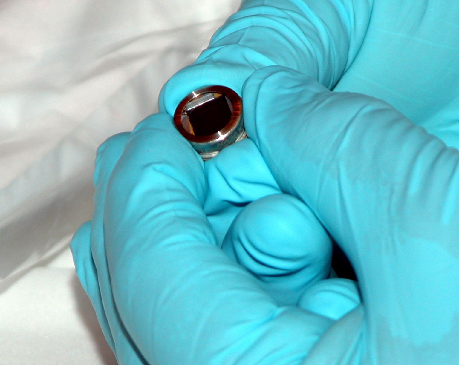 This closeup shows the size of the computer chip that holds about 35,000 laser-engraved signatures of visitors to the Mars Exploration Rovers at the Jet Propulsion Laboratory.