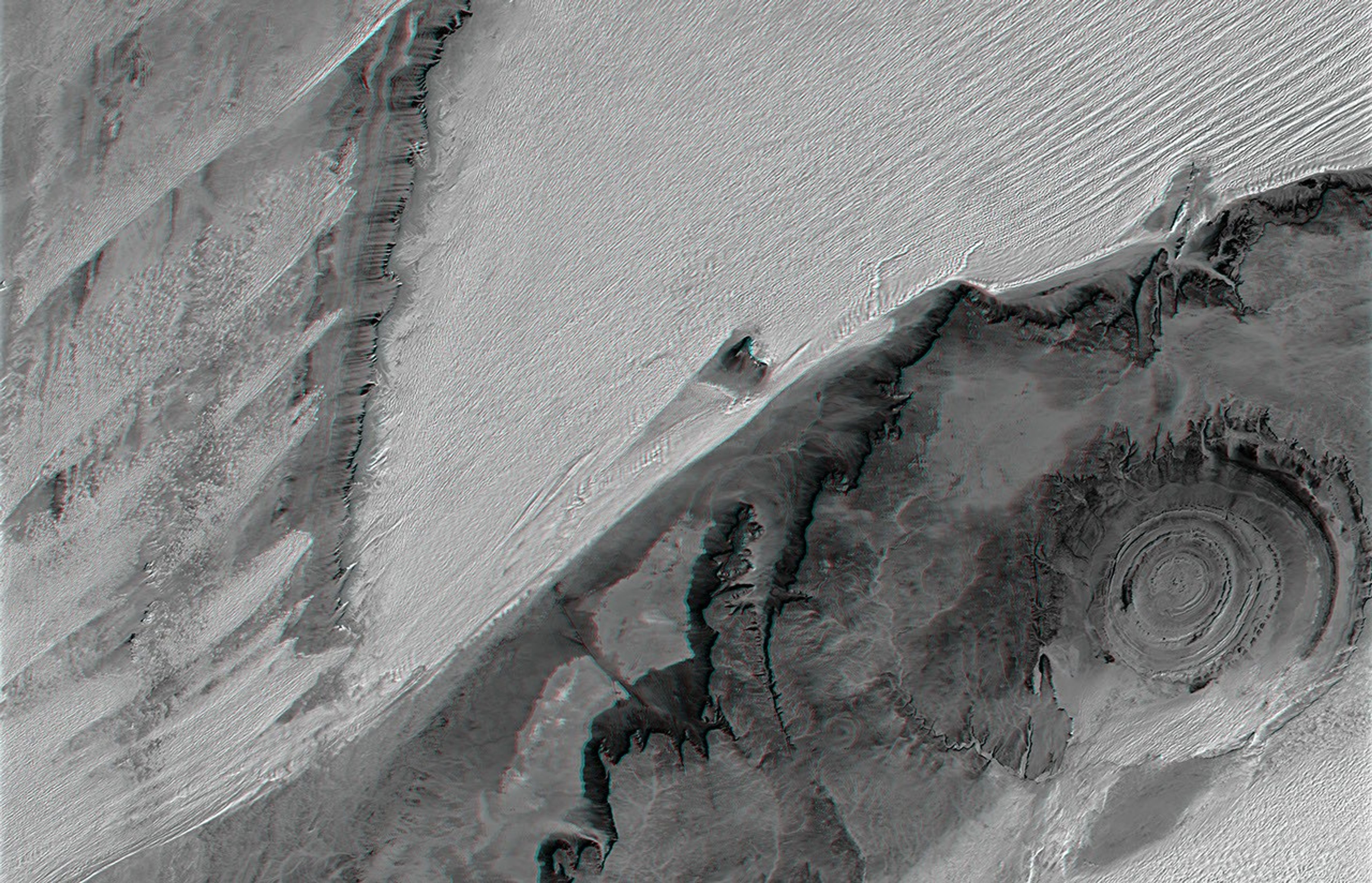 The prominent circular feature seen here is known as the Richat Structure, in the Sahara desert of Mauritania. This anaglyph is from NASA's Shuttle Radar Topography Mission. 3D glasses are necessary to view this image.