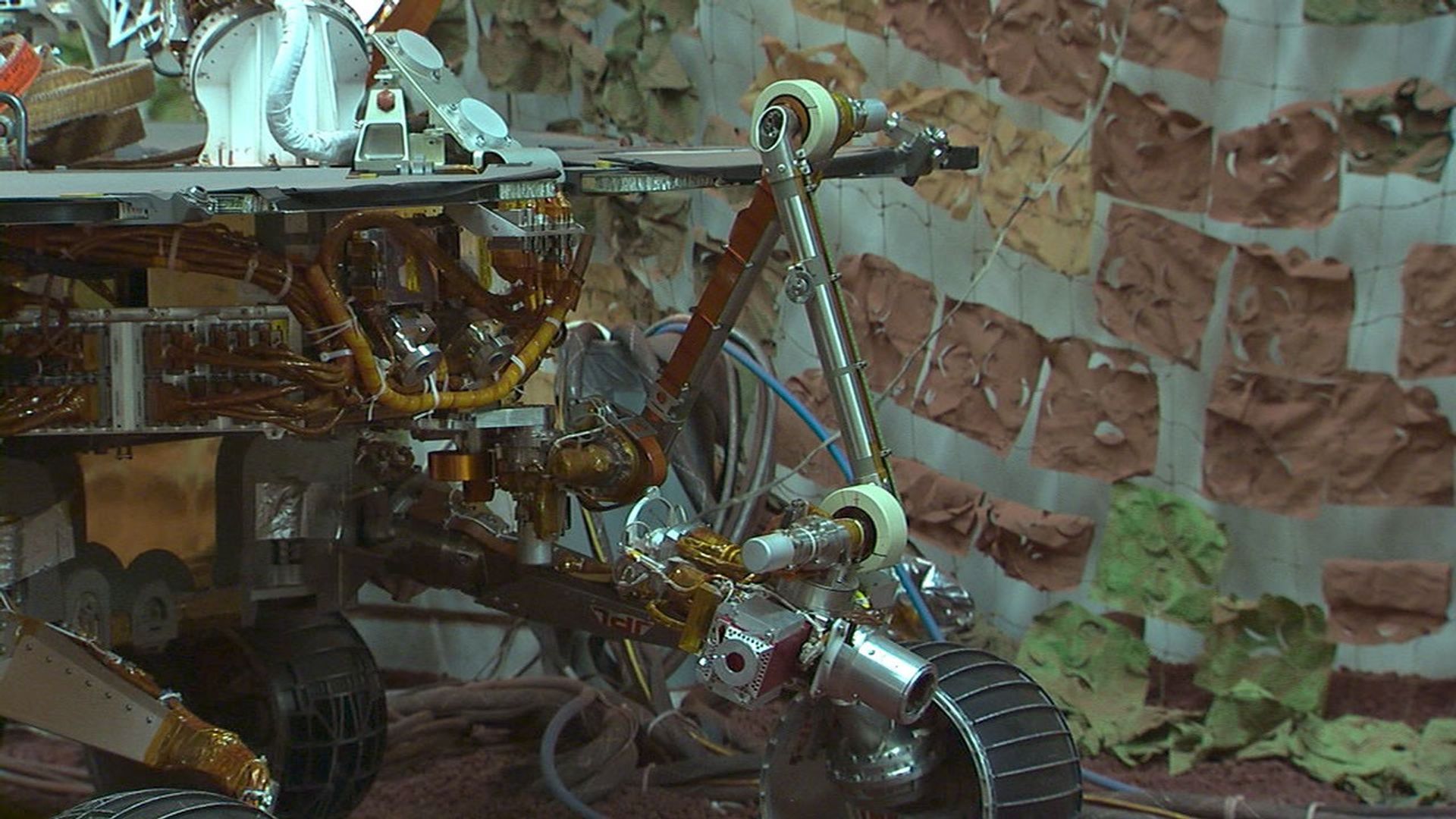 Footage taken at the JPL In-Situ Instruments Laboratory, or 'testbed,' shows engineers practicing the deployment of the test rover's robotic arm.