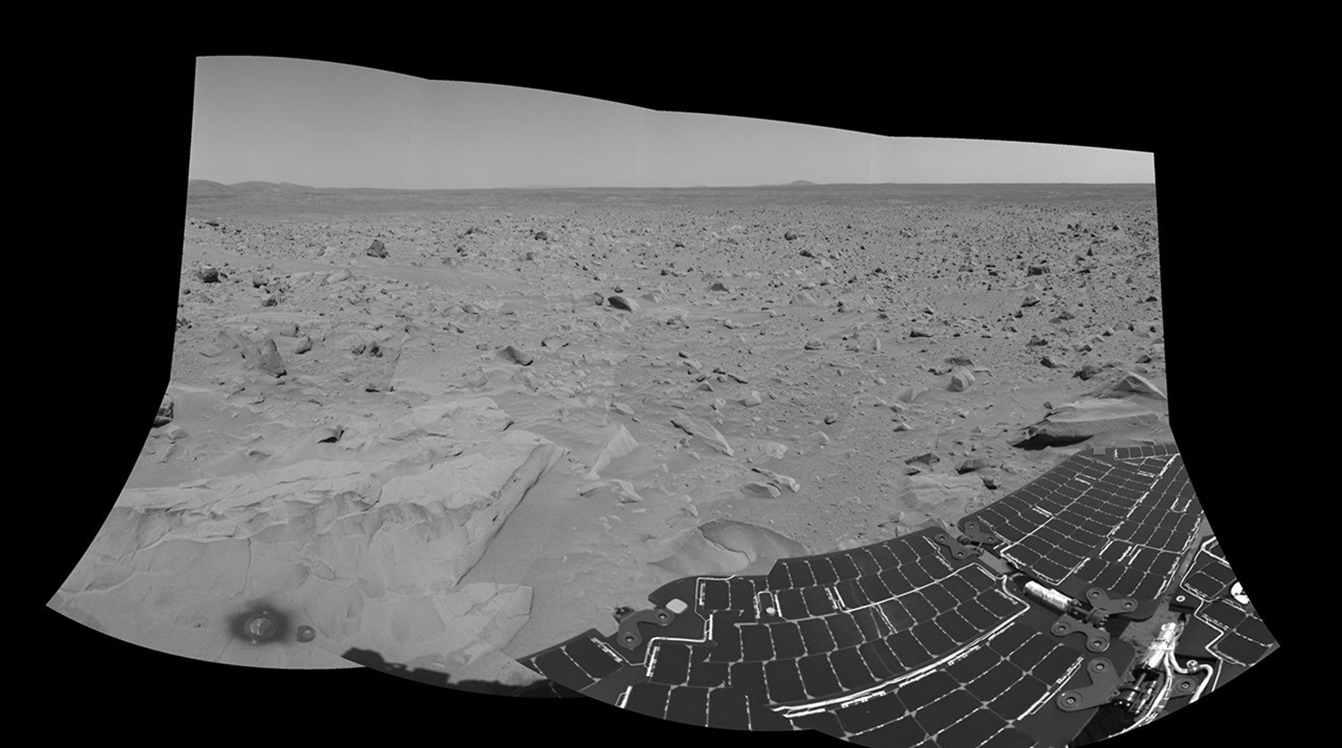 This image taken by NASA's Mars Exploration Rover Spirit shows the view south of the large crater dubbed 'Bonneville.' The rock dubbed 'Mazatzal' and the hole the rover drilled in to it can be seen at the lower left.