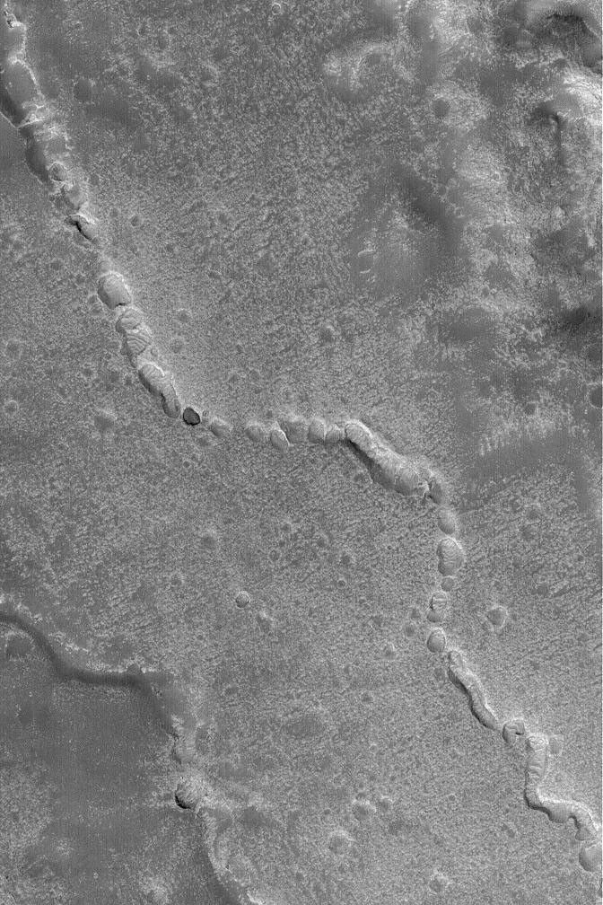 NASA's Mars Global Surveyor shows evidence of a collapsed lava tube (or other form of subterranean channel) on the plains northwest of the Elysium volcanoes on Mars.