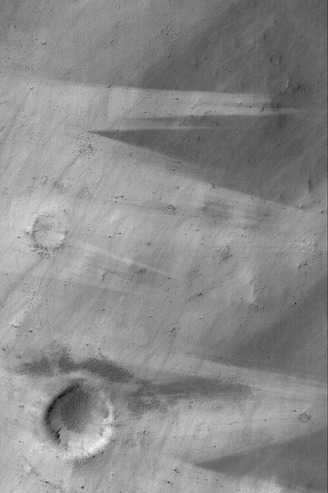 NASA's Mars Global Surveyor shows streak patterns made by wind as it distributed and re-distributed dark sediment across a light-toned substrate west of Schiaparelli Crater on Mars.