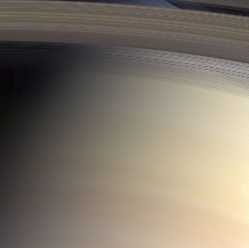 Saturn's faintly banded atmosphere is delicately colored and its threadbare rings cross their own shadows in this marvelous natural color view from NASA's Cassini spacecraft.
