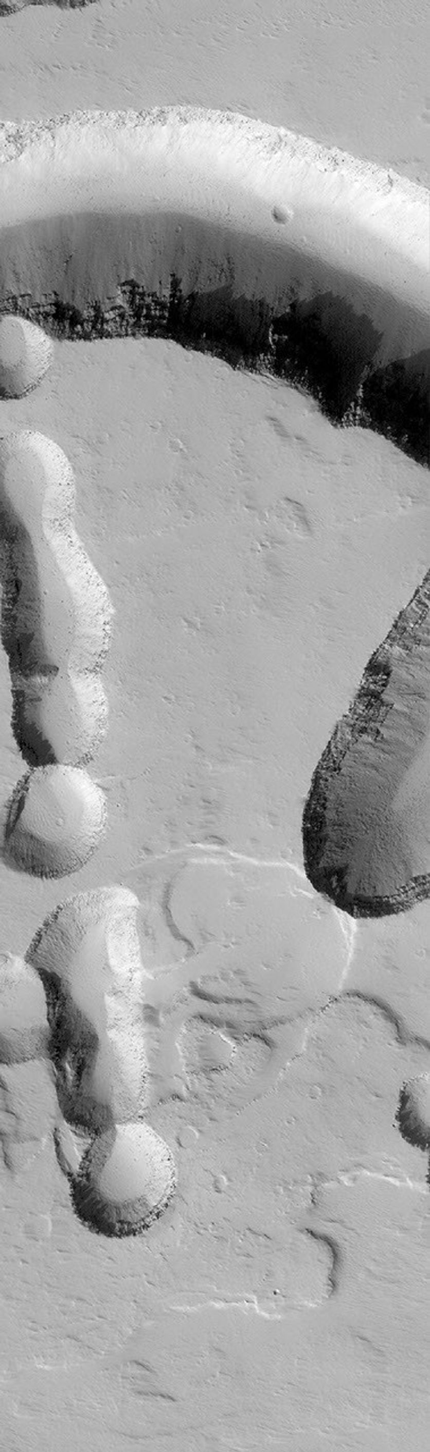 NASA's Mars Global Surveyor shows collapse pits and troughs on the lower northeast flank of the giant martian volcano, Ascraeus Mons on Mars.