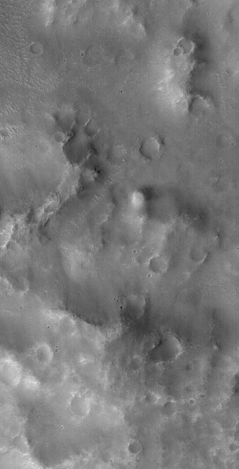 NASA's Mars Global Surveyor shows a fuzzy, nearly-circular bright, active dust devil making its way across the rugged terrain of the Loire Vallis system on Mars.