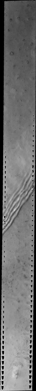 This image released on June 28, 2004 from NASA's 2001 Mars Odyssey was taken during early spring near Mars' north pole. The linear 'ripples' are transparent water-ice clouds.