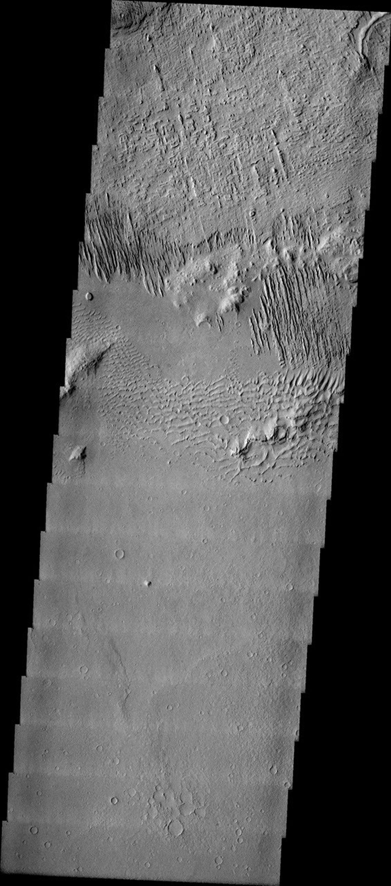 This image released on July 14, 2004 from NASA's 2001 Mars Odyssey shows windstreaks are features caused by the interaction of wind and topographic landforms such as sand dunes with multiple linear ridges. These ridges are yardangs.