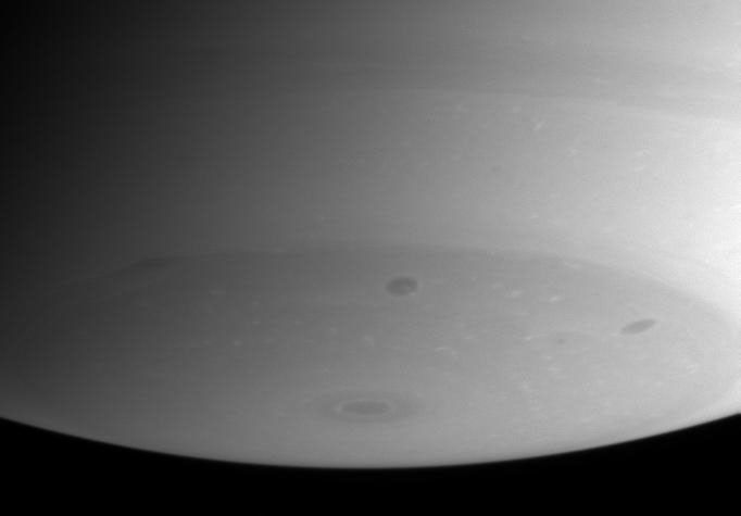 Flecks of bright cloud and several dark storms dominate Saturn's southern polar region, as shown in this image captured by NASA's Cassini spacecraft.