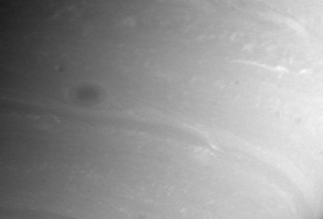 This close-up view from NASA's Cassini spacecraft shows lots of atmospheric detail, including a dark storm and wisps of clouds.