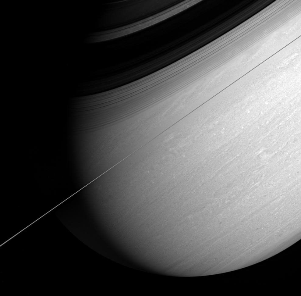 Saturn's whirling vortices and feathery cloud bands are the signs of a restless world. NASA's Cassini spacecraft captured this arresting view of the giant planet scored by bold shadows cast by the rings.