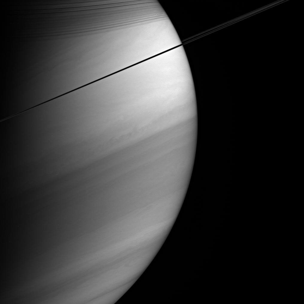 Viewed nearly edge-on, Saturn's rings appear dark and pencil-thin against the backdrop of the planet's swirling clouds. This image was taken with NASA's Cassini spacecraft's wide-angle camera on Feb. 18, 2005.