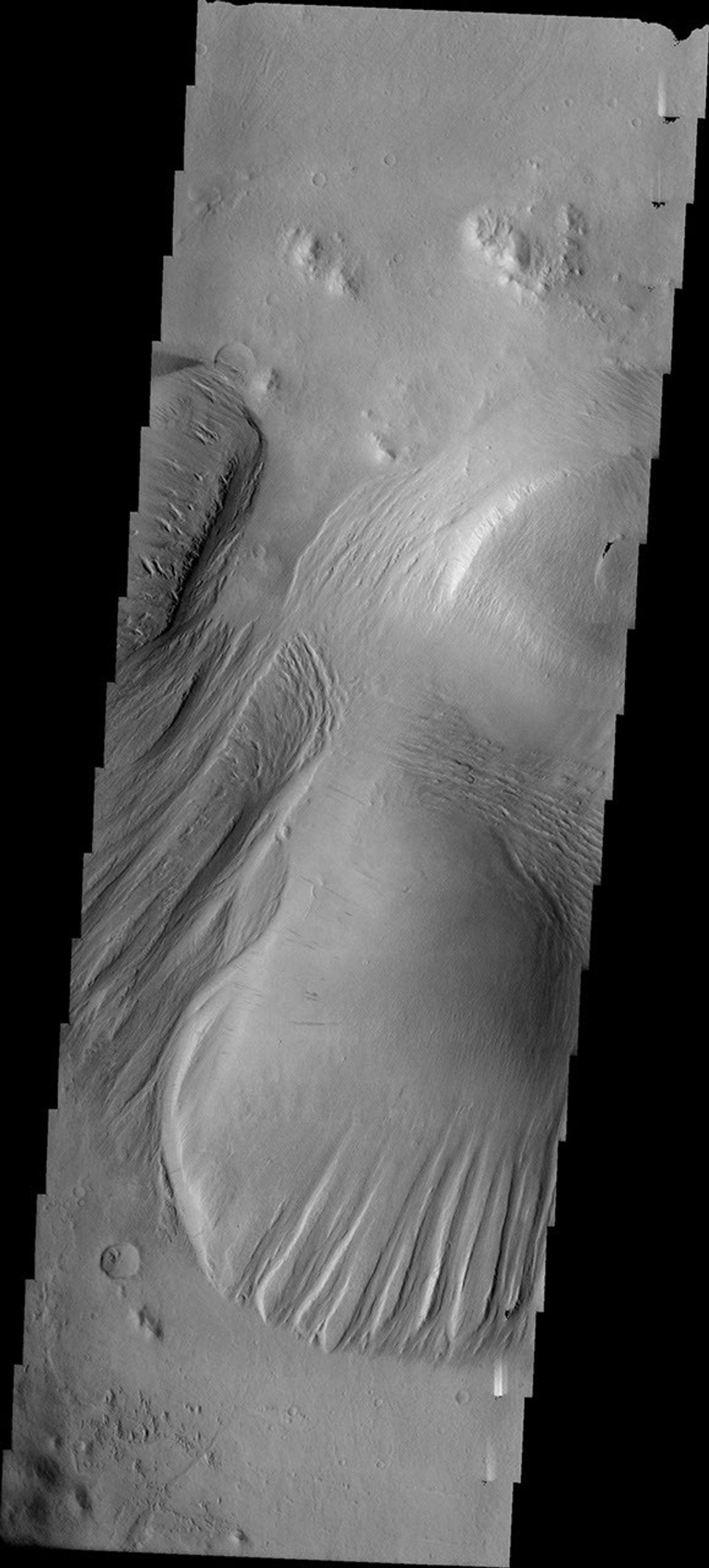 This image released on July 16, 2004 from NASA's 2001 Mars Odyssey shows that eons of atmospheric dust storm activity has left its mark on Mars. Here are different amounts of yardang development on a large deposit found on the floor of Nichols.