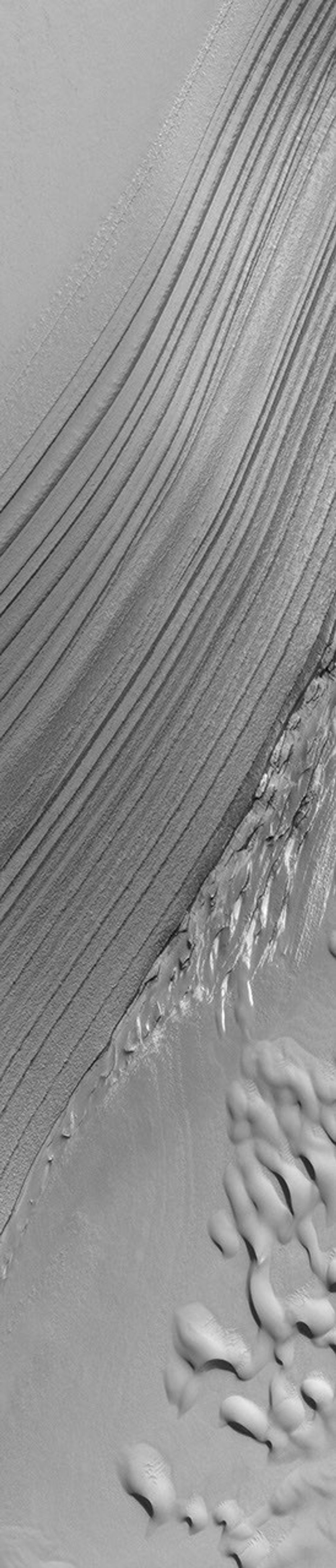 NASA's Mars Global Surveyor shows layer outcrops and sand dunes in the Chasma Boreale portion of the martian north polar cap.