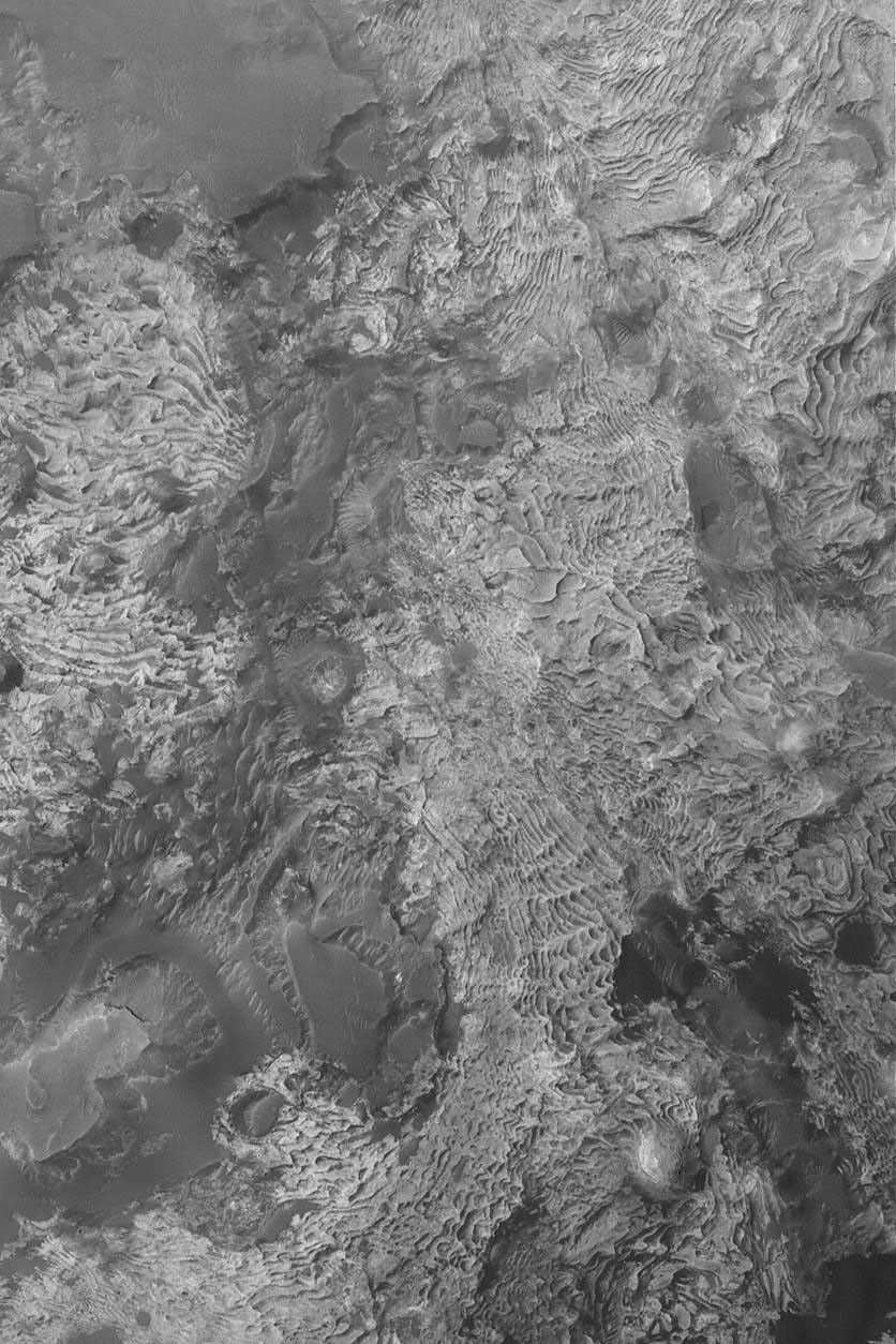 NASA's Mars Global Surveyor shows eroded layered rock outcrops in a crater north of Meridiani Planum on Mars. The crater in which these layers occur may once have been completely filled and buried.