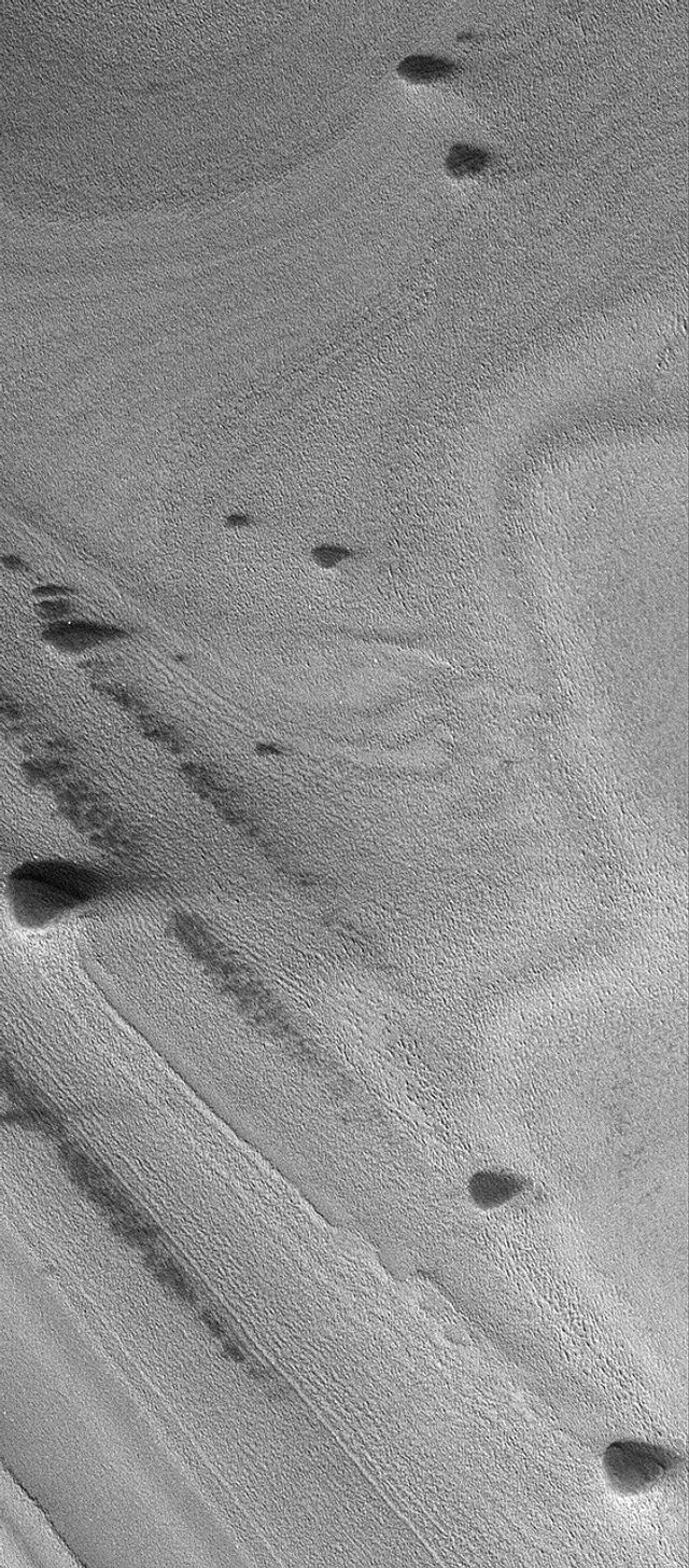 NASA's Mars Global Surveyor shows banded terrain of the north polar region of Mars. The bands are exposures of layered material, possibly composed of dust and ice.