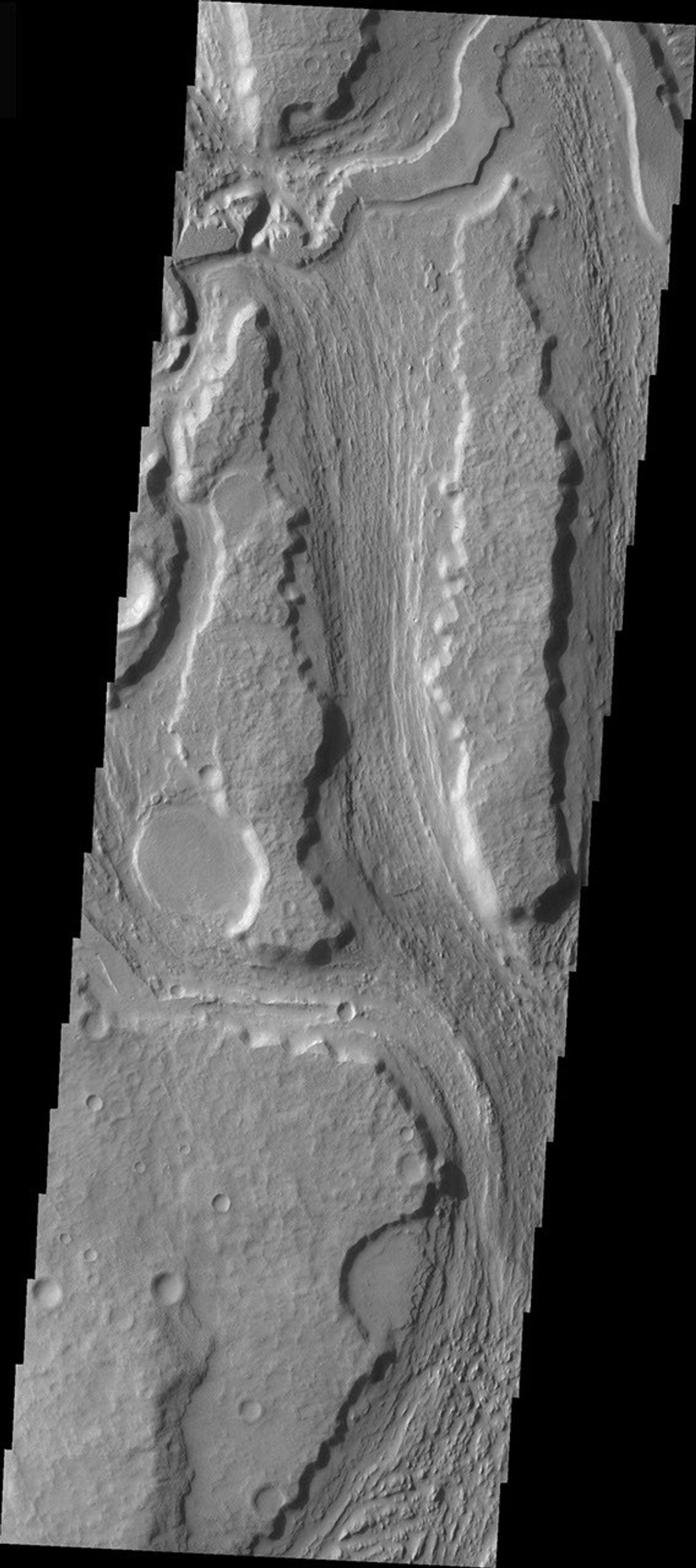 This image released on Nov 29, 2004 from NASA's 2001 Mars Odyssey shows the southern reach of Minio Vallis on Mars, a small fluvial channel located near the larger Mangala Vallis. Both channels are in the Tharsis region, in the area west of Arsia Mons.