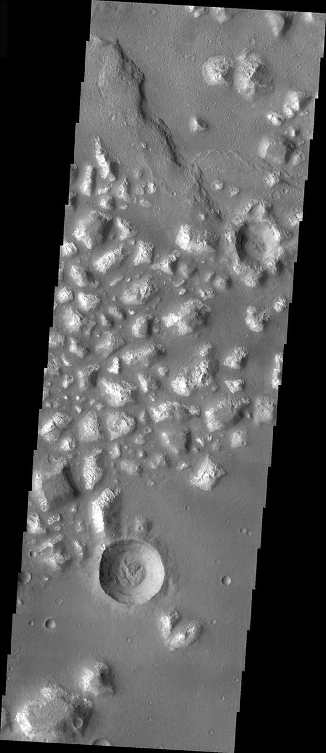 This image from NASA's Mars Odyssey is of a crater on Mars, located in Mare Chromium, showing evidence of exterior modification, with little interior modification. While the rim is still visible, the ejecta blanket has been removed or covered.